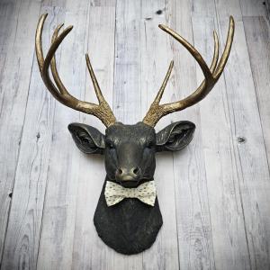 Faux taxidermy deer head, painted slate grey with antique gold accents.  A rovable bow tie accents the neck of the deerem.