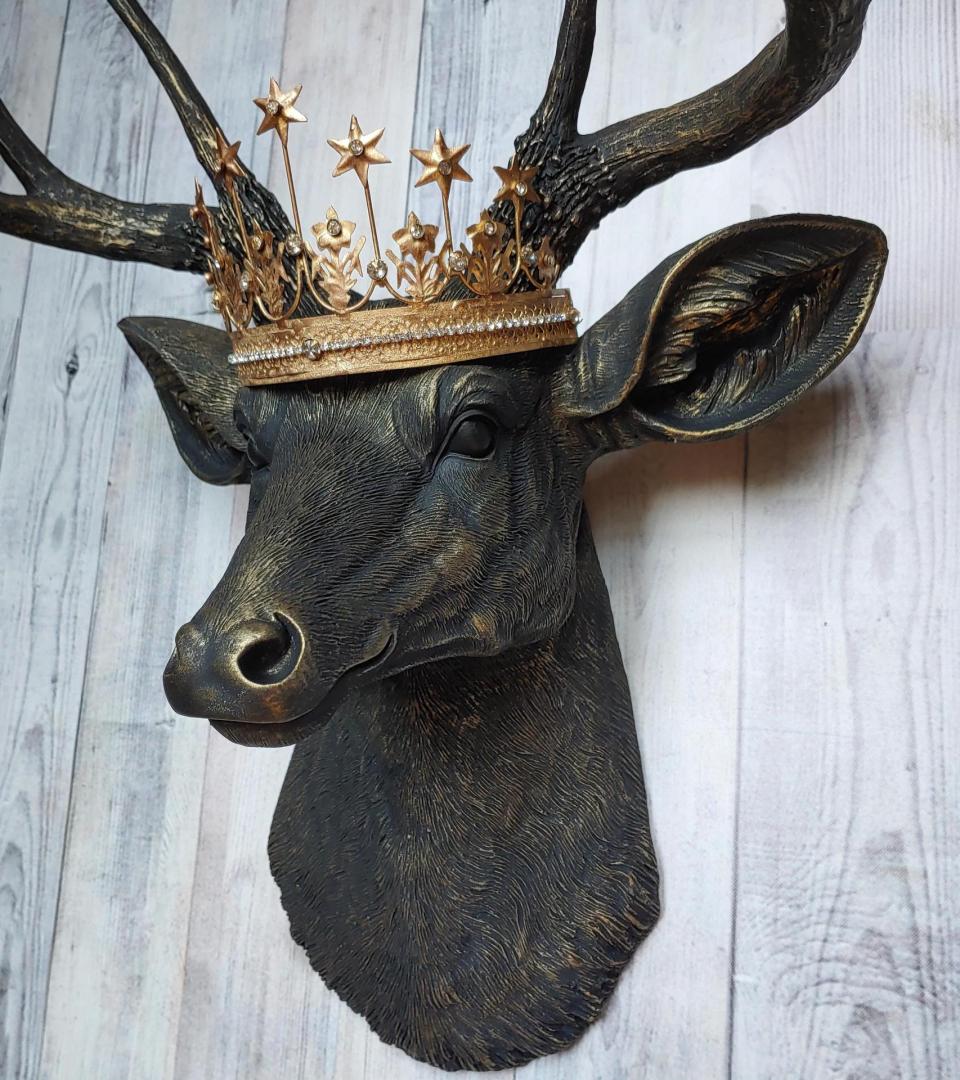 Faux taxidermy deer head wall mount painted black with gold accents. A gold Santos star crown accents the top of the deers head.