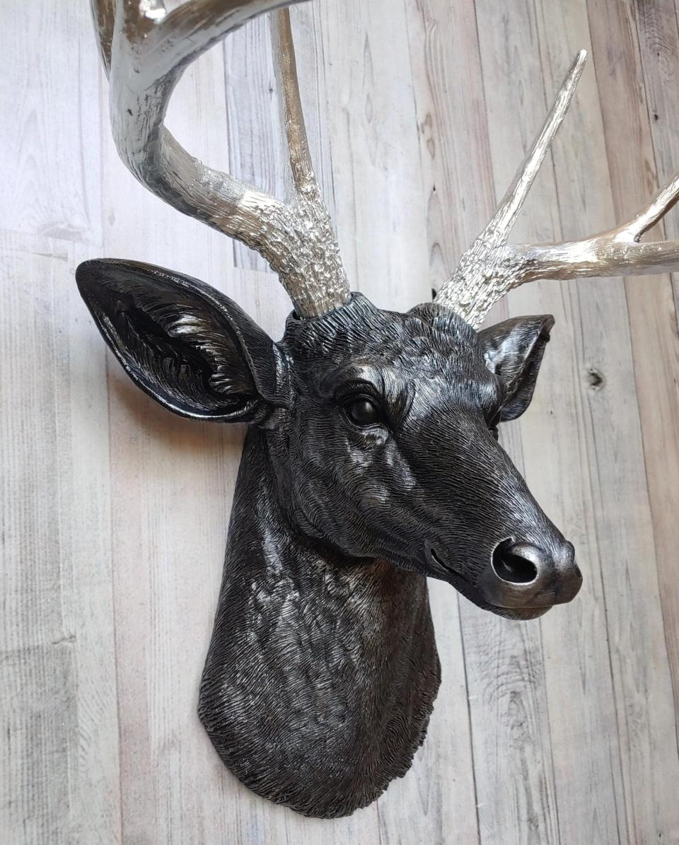Faux taxidermy deer head, painted black with silver accenting on the deers head, the antler have been painted metallic silver.