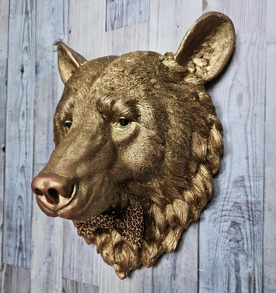 faux taxidermy bear head wall mount, painted gold with rose gold accents. a leopard bow tie accents the neck of the bear